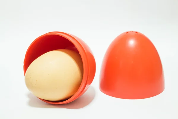 Красное яйцо на белом столе — стоковое фото