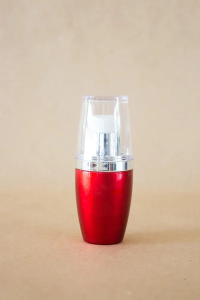 Kahverengi zemin üzerine parlak sabit kırmızı şişe — Stok fotoğraf