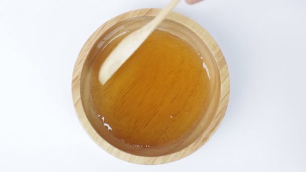 Wooden spoon of honey cup on top view — Stock Video