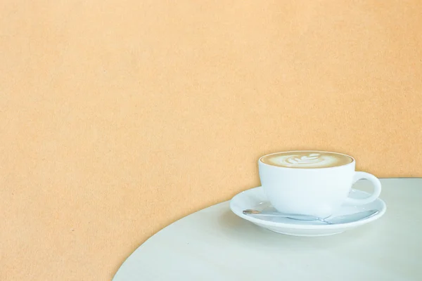Weiße Tasse Kaffee Latte auf braunem Papierrücken — Stockfoto