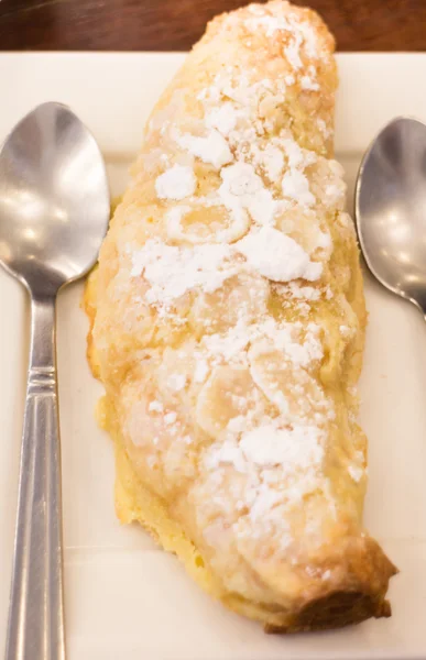 Delicious almond croissant sprinkled with icing sugar — Stock Photo, Image