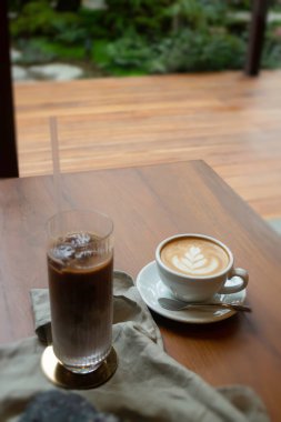 Sıcak kahve ve ahşap masada buzlu kahve.