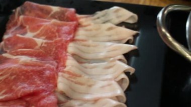 Shabu zamanı sıcak tencerede yemeğin tadını çıkarıyor.