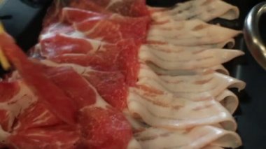 Shabu zamanı sıcak tencerede yemeğin tadını çıkarıyor.