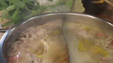 Shabu zamanı sıcak tencerede yemeğin tadını çıkarıyor.