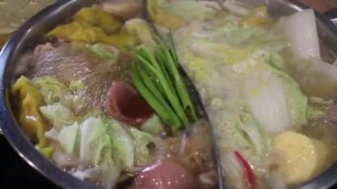 Shabu zamanı sıcak tencerede yemeğin tadını çıkarıyor.