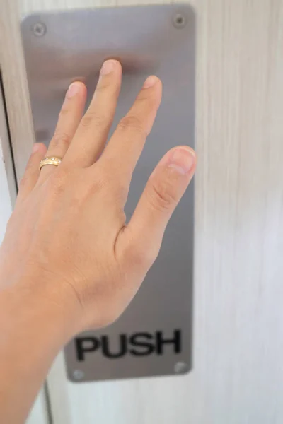 Woman hand pushing the door, stock photo