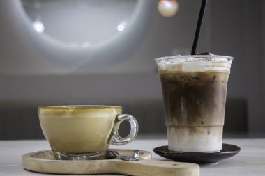 Bir fincan sıcak kahve, yanında sanat eseri ve fotoğraf.