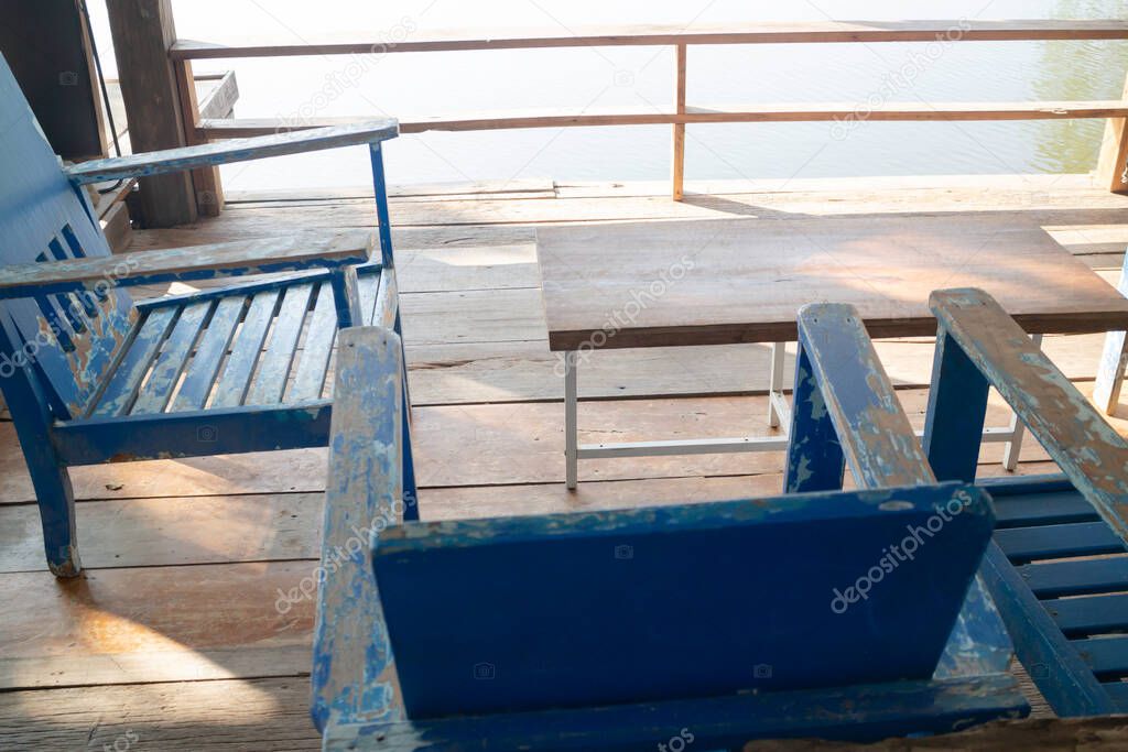 Wooden chairs on wood pier overlooking lake, stock photo
