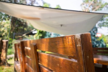 Güzel yeşil bir yaz bahçesi, açık sandalyeli, resimli.