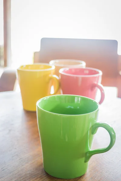 Tasses à café en céramique colorée sur la table en bois — Stockfoto