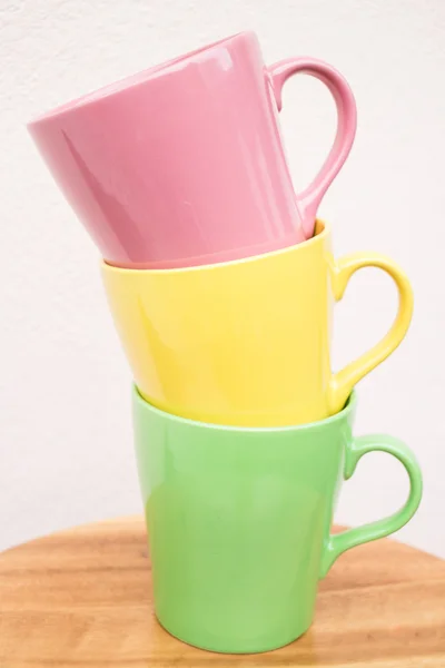 Tazas de taza multicolor en mesa de madera —  Fotos de Stock