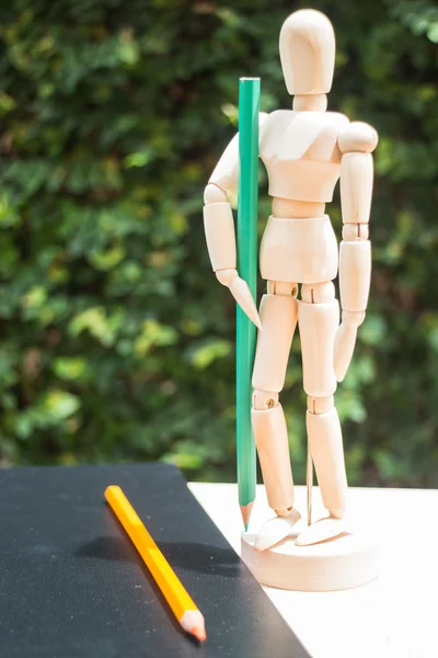 Wood artist mannequin standing with colour pencil — Stock Photo, Image