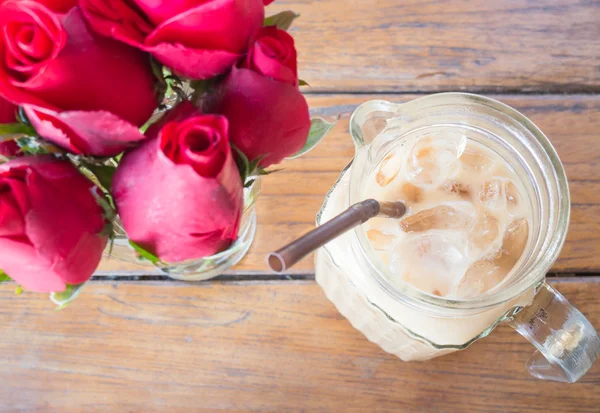 Romantická výzdoba tabulka s ledovou kávu latte a červené růže — Stock fotografie
