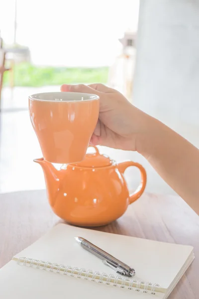 Hand houden op warm kopje thee — Stockfoto