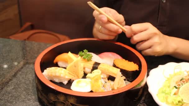 Sushi door beschikbare eetstokjes houden — Stockvideo