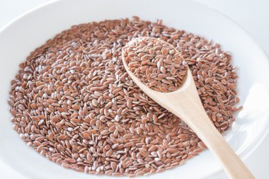 Bir tahta kaşık üzerinde kahverengi keten tohumu