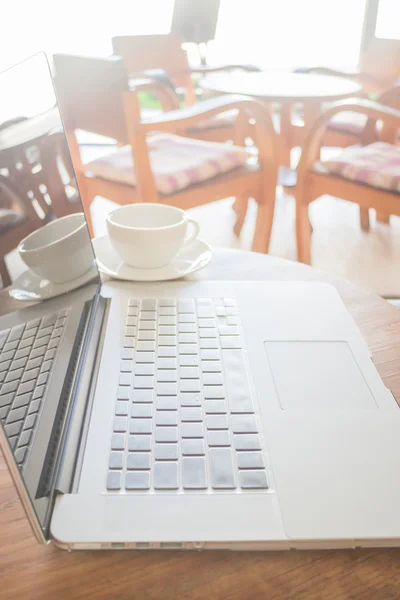 Espaço de trabalho com laptop e xícara de café na mesa de madeira — Fotografia de Stock