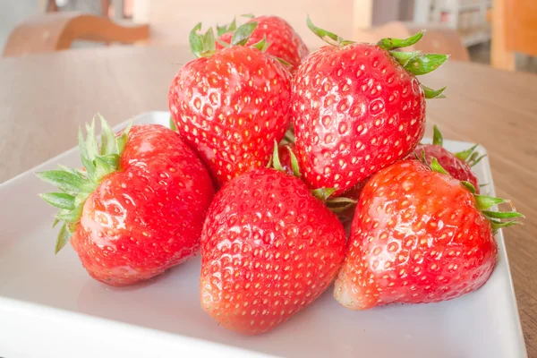 Frische reife Erdbeeren auf weißem Teller — Stockfoto