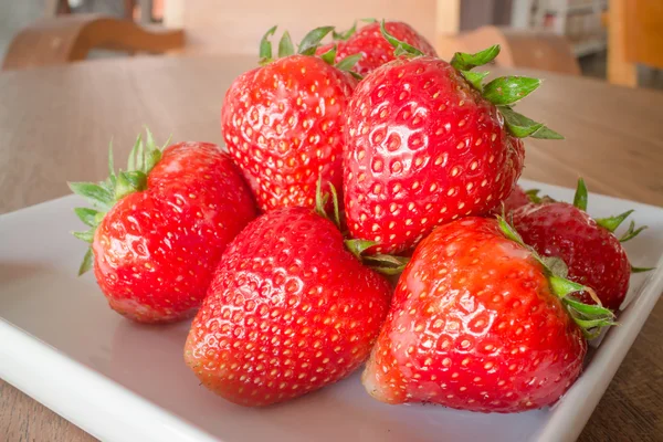 Frische reife Erdbeeren auf weißem Teller — Stockfoto