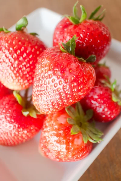 Frische reife Erdbeeren auf weißem Teller — Stockfoto