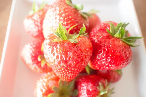 Frische reife Erdbeeren auf weißem Teller — Stockfoto