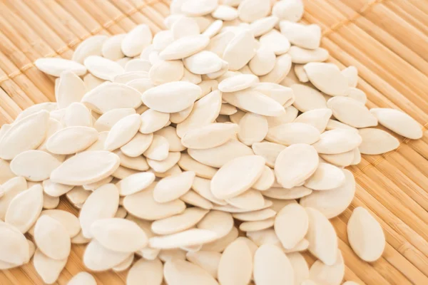 Pumpkin seeds on kitchen bamboo mat — Stock Photo, Image