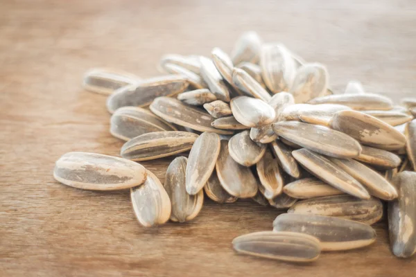 Sunflower seeds on weathered wood — Stock Photo, Image