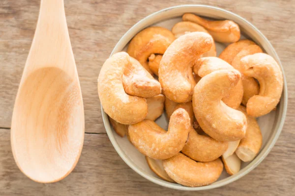 Cashew nut roast salt on weathered wooden table — Stock Photo, Image