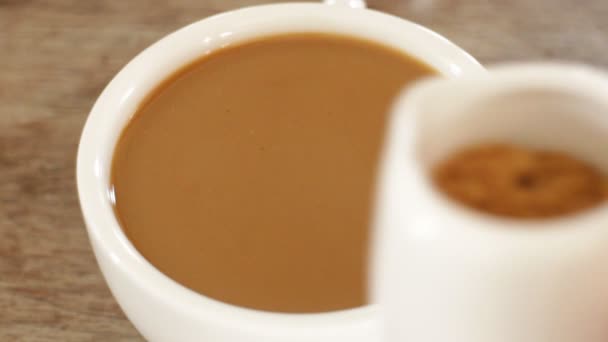 Het toevoegen van bruine suiker aan een kopje melk koffie, Stock video — Stockvideo