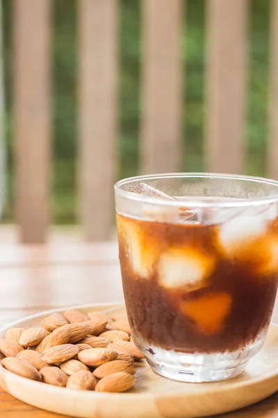 Copo de café gelado preto com grão de amêndoa — Fotografia de Stock