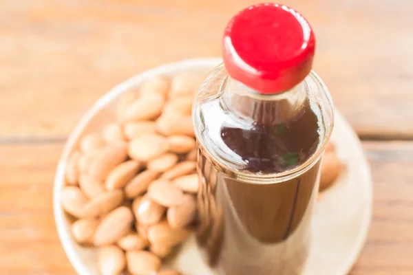 Bottle of black iced coffee with almond grain — Stock Photo, Image