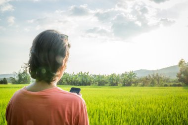 Asyalı kadın mobil hizmet telefon Internet pirinç fiel önünde