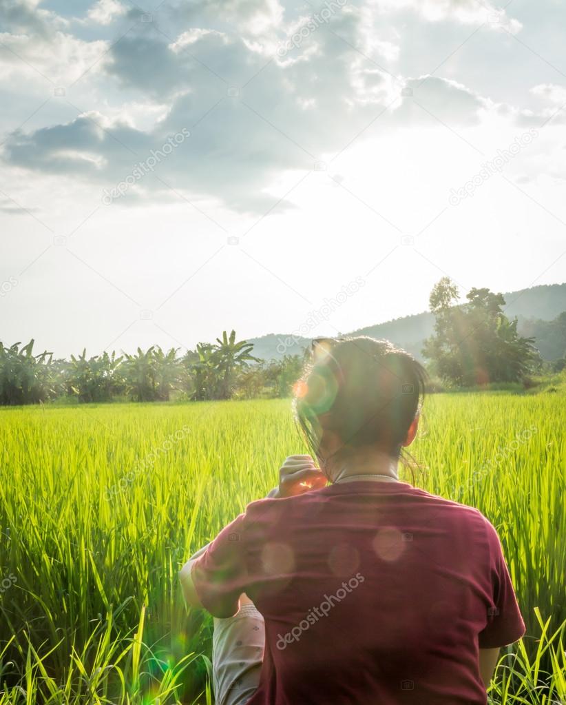 Asian woman enjoy green scenery of  rice field