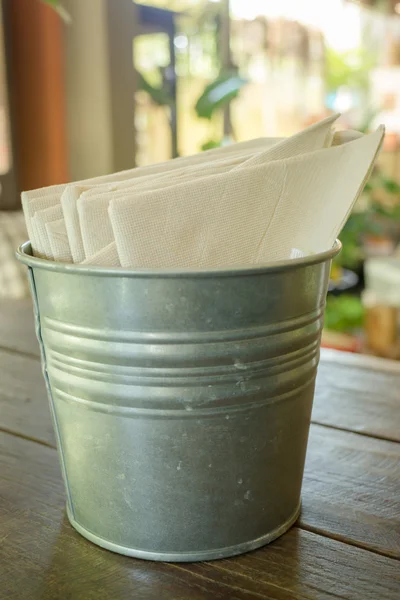 Tissue paper in bucket on wooden table — Stock Photo, Image