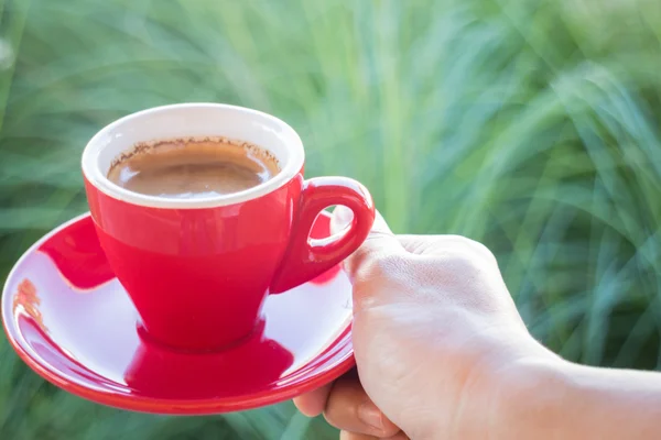 Frau hält eine rote Kaffeetasse in der Hand) — Stockfoto