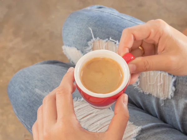 Kvinna i trasiga jeans sitter på kafé — Stockfoto