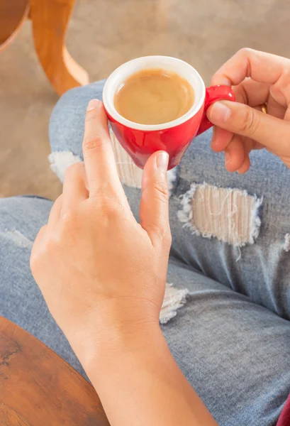 Woman in torn jeans sitting at coffee shop — Stock Photo, Image