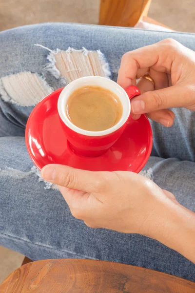 Woman in torn jeans sitting at coffee shop — Stock Photo, Image