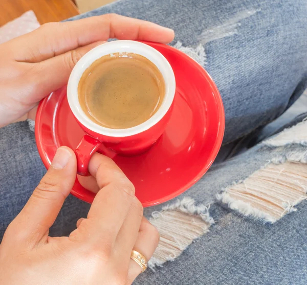 Woman in torn jeans sitting at coffee shop