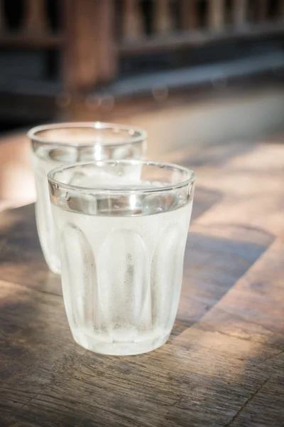 Pokój Dwuosobowy szklanek zimnej wody na drewnianym stole — Zdjęcie stockowe