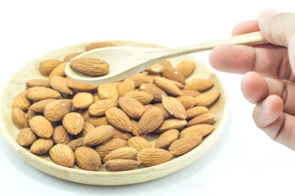 Hand on spoon of almond isolated on white background — Stock Photo, Image