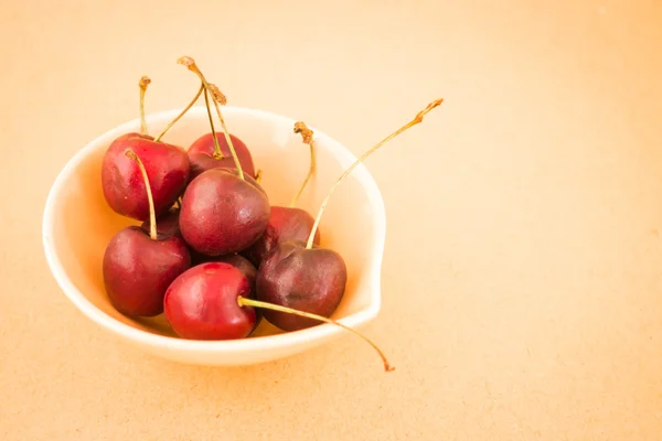 Bowl of cherries on warm vintage background — Stock Photo, Image