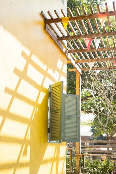 Window on yellow cement with shadows — Stock Photo, Image