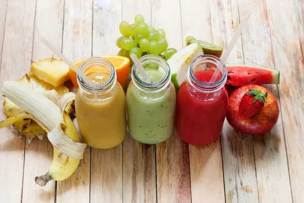 Reihensaft Smoothie Flaschen rot grün orange Früchte — Stockfoto