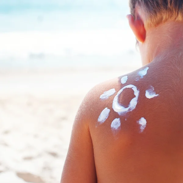 Suntan Boy signo sol crema mar fondo — Foto de Stock