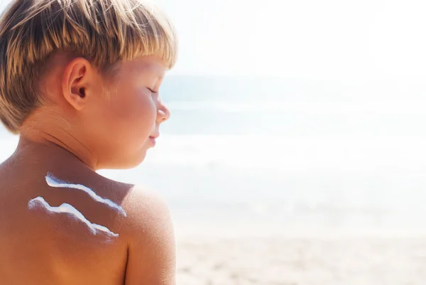 Suntan Boy signo onda sol crema mar fondo — Foto de Stock