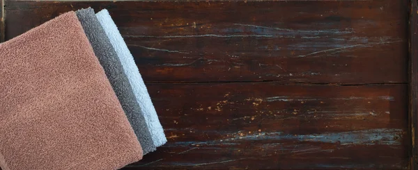 Bovenaanzicht van stapel bad handdoeken houten achtergrond — Stockfoto
