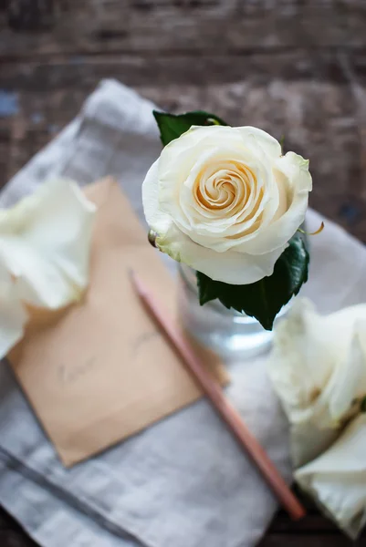 Rosa blanca en vidrio y carta con lápiz. Mensaje Love You —  Fotos de Stock