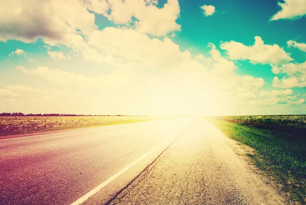 道路フィールド風景青い空の地平線上の太陽の光 — ストック写真